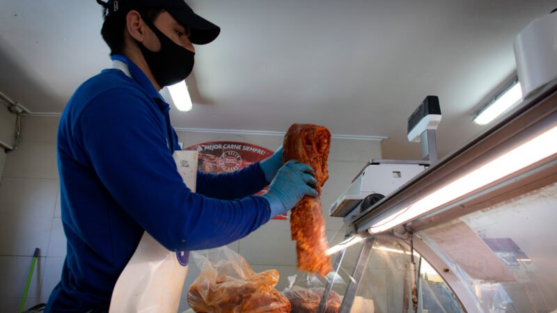 Carnicero preparando un corte detrás del mesón
