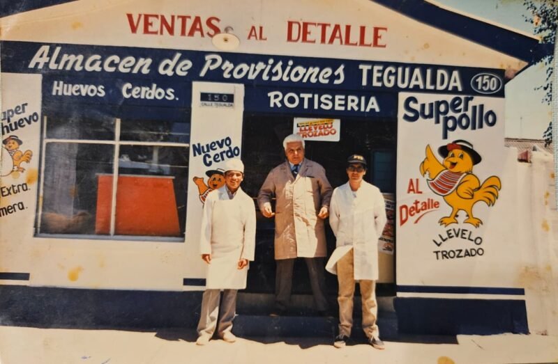 Foto antigua del local de Tegualda: tres carniceros de delantal blanco frente al local, con carteles de Super Pollo y Rotisería